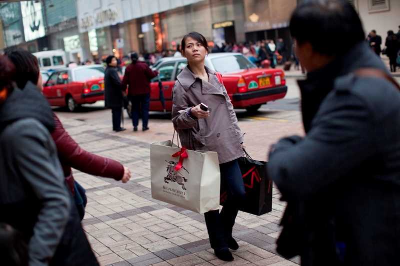 Kvinne på gaten som bærer på handleposer