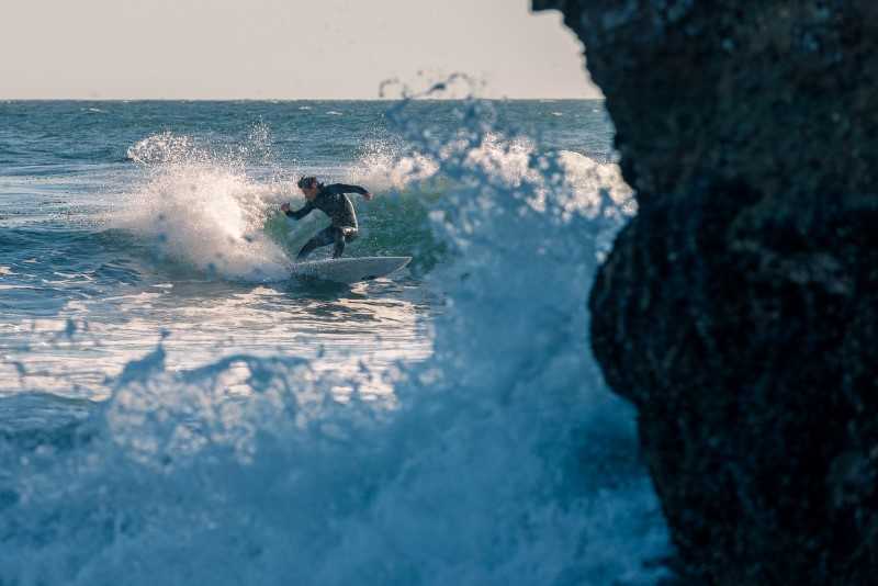 Mann på surfebrett i urolig sjø