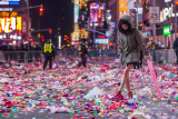 Kvinne går rundt i konfetti på Times Square etter nyttårsfest