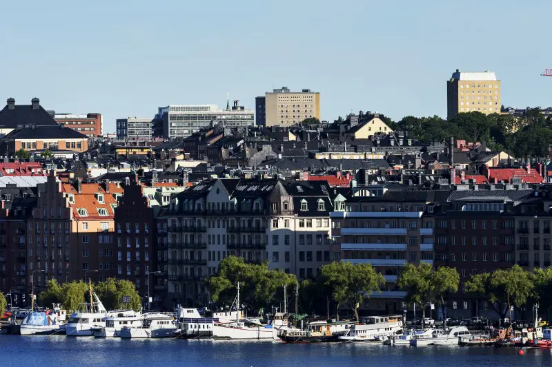 Båter på vannet med by i bakgrunnen